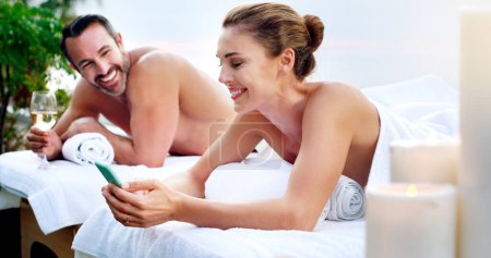 Photo for Couple, spa and massage table for outdoor treatment with cellphone or champagne, skincare or stress relief. Man, woman and zen resort for honeymoon travel for beauty wellness, texting or social media. - Royalty Free Image