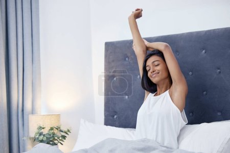 Photo for Morning, wake up or Indian woman stretching arms in bedroom for resting in pyjamas in home. Eyes closed, relax or calm female person sleeping on break ready to start day or chill on weekend in house. - Royalty Free Image