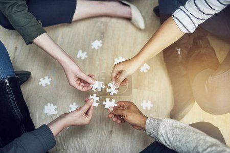 Photo for People, support and hands with puzzle on floor for problem solving, strategy and synergy in training. Team, diversity and partnership with jigsaw for collaboration, growth and creative development. - Royalty Free Image