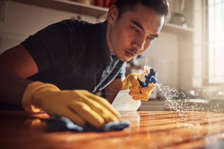 Photo for Home, cleaning and man with disinfectant for kitchen counter, housekeeping and chore. Person, cleaner and guy with spray bottle, cloth and routine with spring cleaning, remove dust and bacteria. - Royalty Free Image