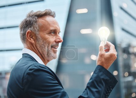 Photo for City, mature or businessman with light for idea, innovation and creative knowledge for vision or sustainability. Happy CEO, solution or eco plan for renewable energy, electricity or power saving bulb. - Royalty Free Image