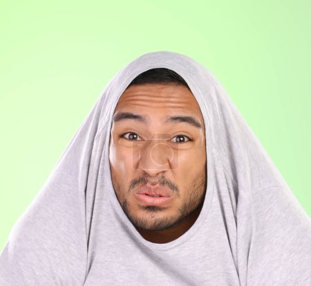 Photo for Man, portrait and silly face with disgust for funny smell, self esteem or ego on a green studio background. Shy male person or joker with goofy expression, attitude or childish behavior in discomfort. - Royalty Free Image