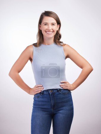 Photo for Confident, fashion model or happy woman in portrait or studio for cool style, trendy jeans or comfortable outfit. Chic, lady and proud person in casual clothing on grey background with smile or joy. - Royalty Free Image