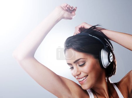 Photo for Woman, music and fun dancing with confidence, freedom and excited with smile and casual fashion in studio. Young student and happy with audio and joy with grey background and carefree from party song. - Royalty Free Image