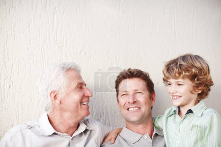 Photo for Hug, father and grandfather or son with smile for bonding, love or relax with generations by wall. Happy family, men or boy child in home for support, mockup space or embrace with confidence or pride. - Royalty Free Image