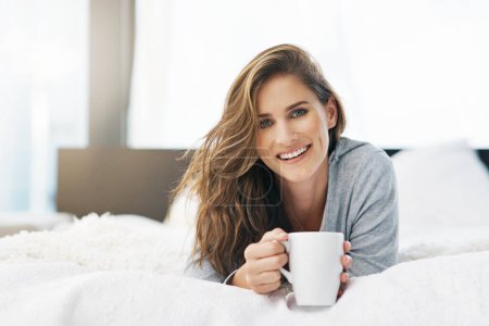 Photo for Woman, portrait and relax on bed for tea for weekend break, peace or wellness in apartment or home. Wake up, morning or happy person resting on bedroom or day off drinking coffee or beverage. - Royalty Free Image