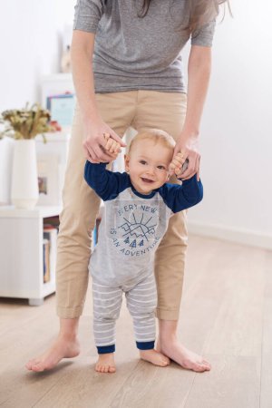 Photo for Mother, child and walking for development, growth and motor skills in childhood as baby at home. Woman, toddler and play for learning, cognition and support in living room for mobility or balance. - Royalty Free Image