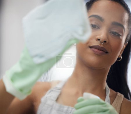 Photo for Gloves, cloth and woman cleaning window at apartment to prevent dirt, germ and bacteria for hygiene. Detergent, surface and female person wiping or washing glass door for housekeeping at modern home - Royalty Free Image