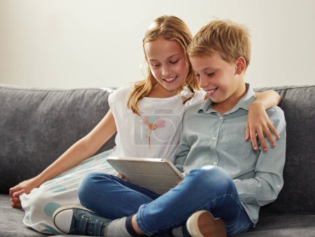 Los niños, sonrisa y tableta en el sofá para la gamificación, el aprendizaje y el desarrollo de películas en línea o juegos virtuales. niños, abrazo y tecnología digital en salón para video, streaming y feliz por internet.