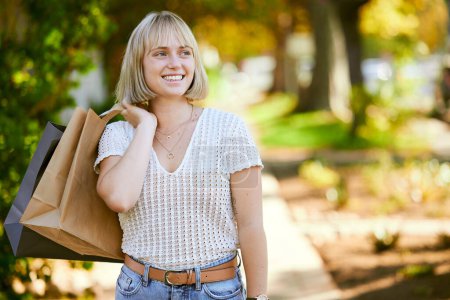 Woman, shopping bag and excited on walk at park with ideas, discount and deal at retail sale. Girl, person and thinking with paper package for sustainability, ecology or customer experience in Berlin.