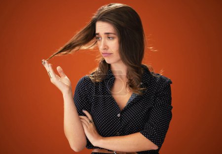 Studio, unhappy and woman with hair, damage and hairloss with split ends, dry and treatment for haircare. Red background, mockup and girl with texture, entangled and matted with cosmetics in salon.