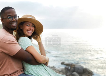 Téléchargez les photos : Couple interracial, portrait et heureux pour câlin par la plage, la nature et l'océan ou la mer pour des vacances au Brésil. Aventure, personnes et sourire sur la route en plein air pour des vacances, voyage et se détendre ensemble. - en image libre de droit