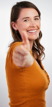 Foto de Mujer feliz, retrato y bien hecho con los pulgares hacia arriba para ganar o el éxito en un fondo gris estudio. Persona femenina con sonrisa, como emoji o sí signo de ok, buen trabajo o gracias por su aprobación. - Imagen libre de derechos