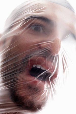 Man, plastic and bag in choking, depression and mania with air in white background. Male person, expression and suffocating in crisis for awareness, help and anxiety in mental health or wellness.