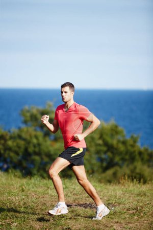 Photo for Sporty, man and jogging in nature for fitness, health and wellness in outdoor for workout or exercise. Male athlete, training and cardio with endurance, muscles and strength for healthy living or gym. - Royalty Free Image