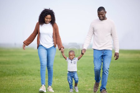 Photo for Black family, holding hands and happy with walking in park for bonding, explore and weekend fun in nature. Father, mother and boy child with smile on field with comfort, security or care with horizon. - Royalty Free Image