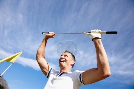 Téléchargez les photos : Homme heureux, gagnant et golfeur avec club dans la célébration de la victoire, la réalisation ou le point avec le ciel bleu. Homme excité ou joueur de sport avec sourire pour marquer, par ou trou dans un au terrain de golf. - en image libre de droit