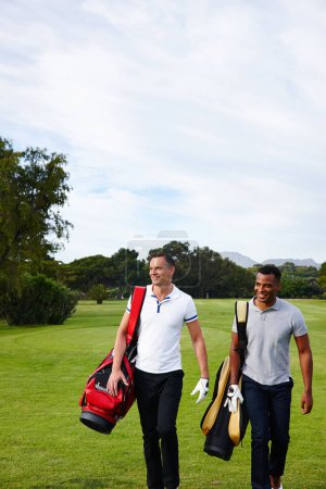 Photo for Men, walking and golf course for professional sport, happy and training together with commitment on field. Athlete, fitness and player by golfing equipment for game and outdoor to exercise on grass. - Royalty Free Image