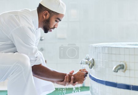 Foto de Lavarse las manos, el musulmán y el hombre con tradición de limpieza en el baño para la religión y la rutina de oración. Islámica, espiritual y eid con cultura y bienestar en mezquita para ramadán y respoect para la fe. - Imagen libre de derechos