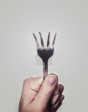 Photo for Bending, fork and hand with closeup, person and utensils with kitchen tool on a white studio background. Mockup space, promotion and model with superpower and magic with design, artistic and creative. - Royalty Free Image