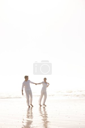 Photo for Couple, ocean and holding hands for walk on beach, travel and commitment with trust and bonding outdoor. Love, care and support in relationship, honeymoon or anniversary with fun or playful in nature. - Royalty Free Image