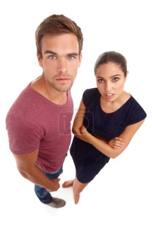 Portrait, top view and annoyed couple in studio with aggressive, attitude or body language on white background. Frustrated, face and people moody with fake news, announcement or marriage counselling.