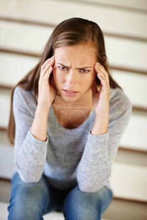 Photo for Portrait, headache and woman in house with stress, frustrated or mental health, crisis or disaster. Stairs, doubt or angry female person face with broken heart overwhelmed by anxiety, fail or mistake. - Royalty Free Image