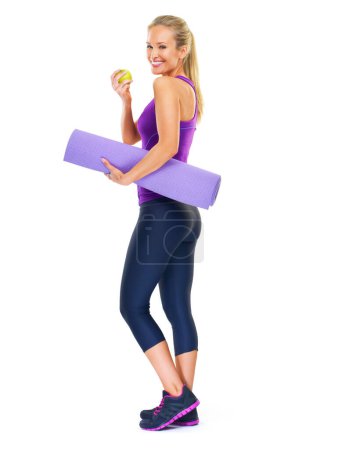 Photo for Woman, portrait and apple with yoga mat in studio, smile and pilates for fitness on white background. Female person, happy and fruit for minerals or vitamins, wellness and healthy diet for fiber. - Royalty Free Image