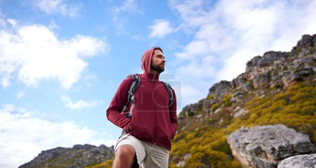Photo for Man, hiking and backpack in outdoor nature, mountain and peace or calm on rocks for wellness. Male person, exercise and travel on weekend vacation, adventure and explore for fitness or trekking. - Royalty Free Image