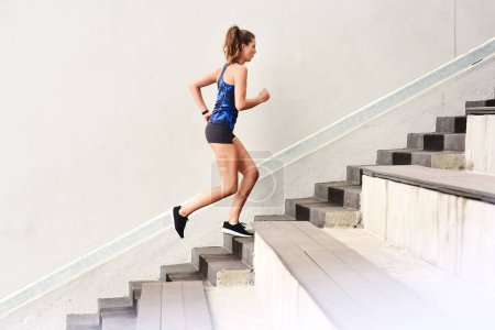 Photo for Female runner, stairs and cardio for sports, exercise and fit on steps for endurance, physical and activity. Healthy, woman and training in running, wellness and muscles for strong, body and mind. - Royalty Free Image