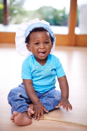 Foto de Bebé negro, retrato y sombrero de chefs en casa en el suelo para los niños jóvenes, jugando y divertido. Niño africano, feliz y sonriente en casa en salón con toque para recreación, recuerdos y vínculo familiar. - Imagen libre de derechos