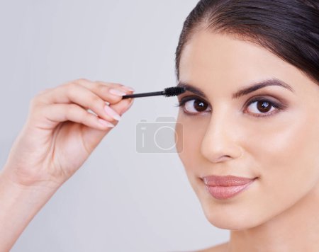 Photo for Hand, mascara and brush with woman in portrait, beauty for lashes and cosmetology on white background. Makeup, glow and transformation for makeover, cosmetic product and wand for eyelash with volume. - Royalty Free Image