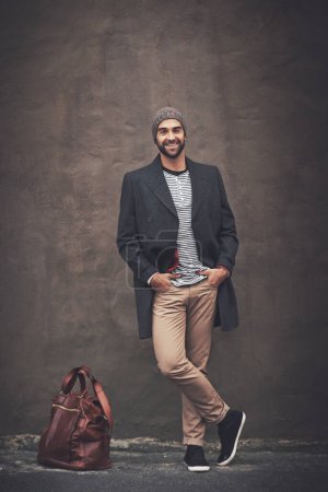 Photo for Man, portrait and smile with downtown, fashion and trendy gentleman jacket. Model, winter and beanie for city, happiness or outdoor positivity for cool hipster style isolated on brown wall background. - Royalty Free Image