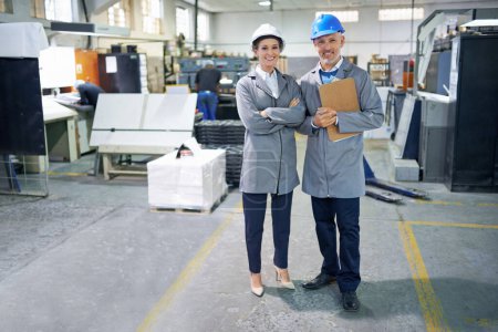 Photo for Professional people, printing and industry in warehouse with clipboard for distribution, admin and packaging. Man, woman and happy in factory with portrait for production, manufacturing and teamwork. - Royalty Free Image