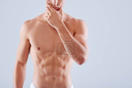 Photo for Muscular man, body and fitness with abs in hygiene, health and wellness on a gray studio background. Closeup of male person or model in wonder with abdominal muscle, torso or strength on mockup space. - Royalty Free Image