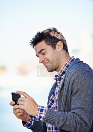 Photo for Man, cellphone and texting at harbor on mobile network by sea for typing, smile and reading outdoor. Person, phone and click at urban port in city for notification, app or social media in Cape Town. - Royalty Free Image