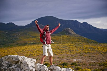 Photo for Happy, mountain and man with celebration for hiking, peak and journey with success and freedom outdoor. Trekking, rock climbing and horizon with arms raised for achievement, travel and adventure. - Royalty Free Image