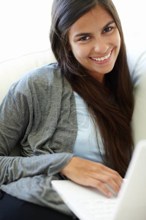 Laptop, relax and portrait of woman with smile, remote working and career of transcriber in house. Living room, employee and female person with happiness with internet online, comfort and couch.