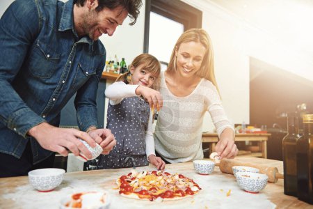 Photo for Portrait, child and happy family baking pizza in kitchen together, bonding and smile for learning in home. Face, mother and father with girl cooking, teaching and help parents with cheese at table. - Royalty Free Image