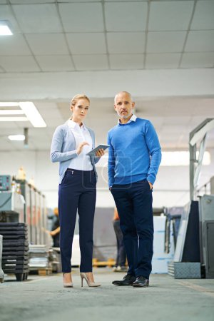 Photo for Portrait, man and woman with tablet in factory for production monitoring, inventory or order management and inspection. Team, digital tech and warehouse for printing material and manufacturing - Royalty Free Image