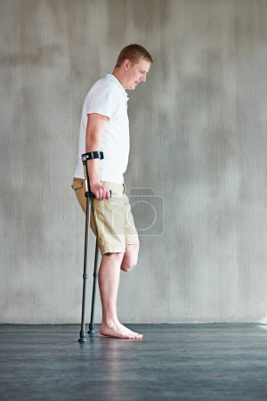 Photo for Physical therapy, person or amputee walking with crutches at clinic for recovery, strength and healthcare rehabilitation. Physiotherapy, support and consultation for patient or man with disability. - Royalty Free Image