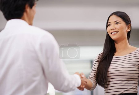 Photo for Happy woman, handshake and meeting with employee in agreement, deal or proposal together at office. Young asian, female person or colleague shaking hands for b2b, greeting or partnership at workplace. - Royalty Free Image