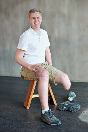 Téléchargez les photos : Homme, heureux et amputé avec prothèse de jambe en salle de gym assis, membre résiduel pour l'équilibre. Séance d'entraînement, physiothérapie et conditionnement physique pour les personnes handicapées, l'exercice et la réadaptation. - en image libre de droit