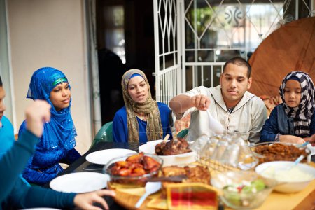 Foto de Familia, musulmán y casa en la cena para eid o ramadán en la mesa para la religión para disfrutar y satisfecho. Fe, Islam y fiesta en la cena de ayuno en traje religioso para la comida y la unión entre sí. - Imagen libre de derechos