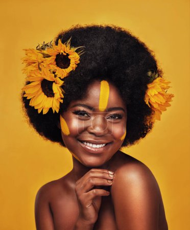 Photo for Black person, portrait and sunflower with skincare in studio for organic cosmetics, treatment or glow. Woman, smile and confident with plant for natural, dermatology or vitamin e on yellow background. - Royalty Free Image