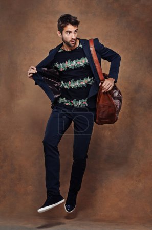 Photo for Fashion, jump and pose for male person, studio and business clothing isolated on background. Confidence, stylish and bag for employee or worker man model, professional and formal and trendy outfit. - Royalty Free Image