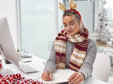 Photo for Christmas, office and business woman writing notes for schedule, reminder or info in creative startup. Planning, notebook and professional on journal for ideas or agenda of secretary on xmas holiday. - Royalty Free Image