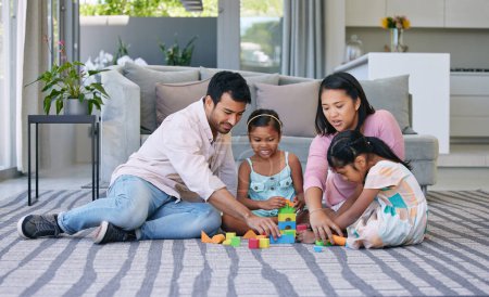 Foto de Mother, father and children playing with building blocks in home on living room carpet, support or bonding. Man, woman and daughter for family connection with development games, education or learning. - Imagen libre de derechos