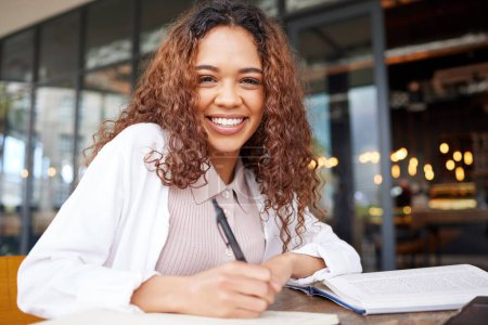 Photo for Student, woman and study with smile for exams preparation or presentation with textbook in cafe. Portrait, college learner and happy or satisfied in restaurant with notes for revision and test. - Royalty Free Image