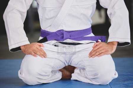 Photo for Martial arts, fitness and person kneeling in gym for training, uniform and professional fighting sport. Health, wellness and Brazilian jiu jitsu athlete in dojo with gi, respect and sitting on mat. - Royalty Free Image